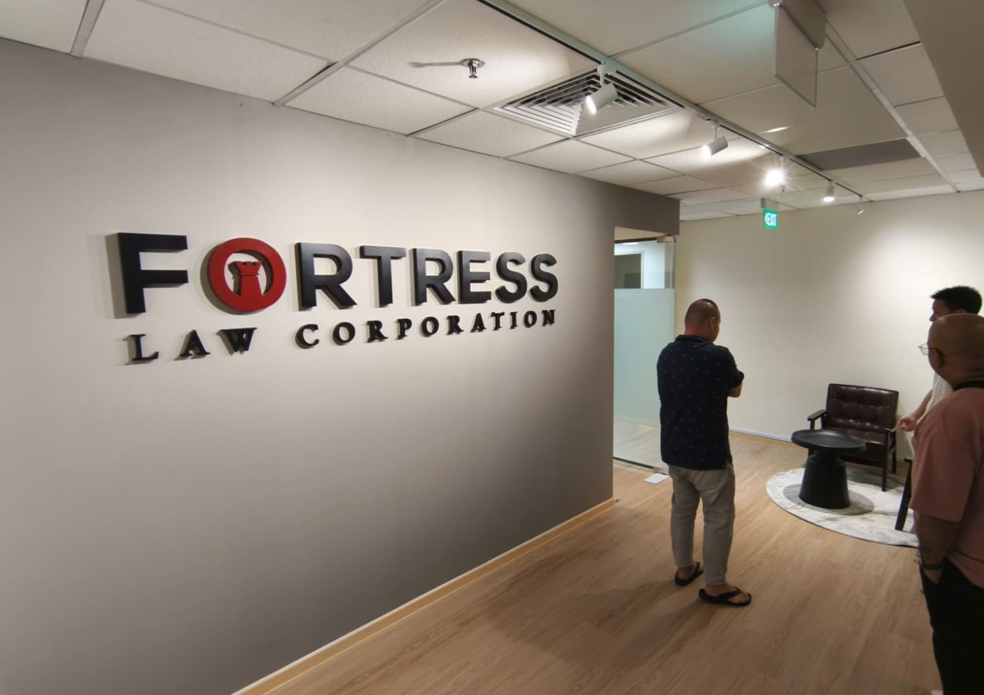 Reception area with branded wall signage and timber flooring at Fortress Law Corporation