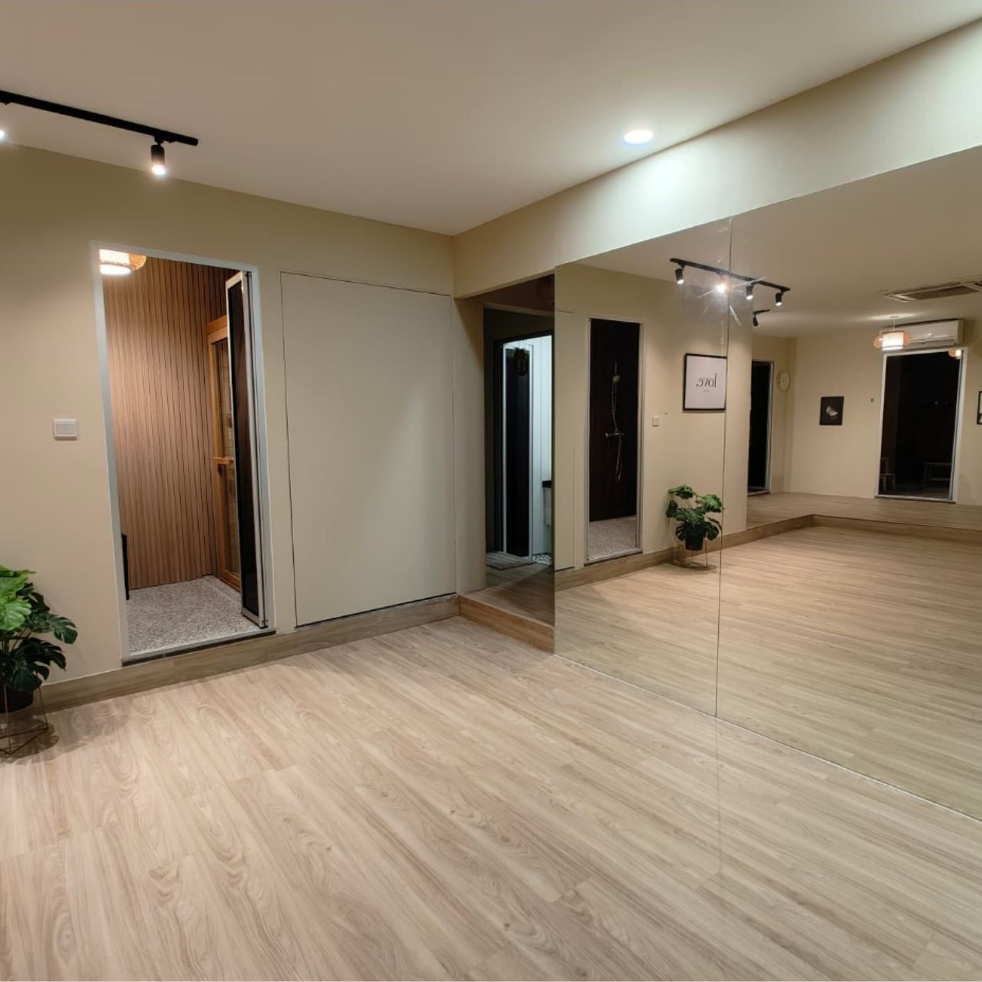 Yoga and activity area with full-wall mirror, sauna room entrance and timber slat surround