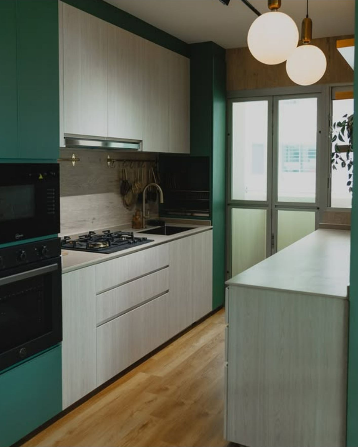 Kitchen with built-in oven, gas hob, custom cabinetry and globe pendant lights